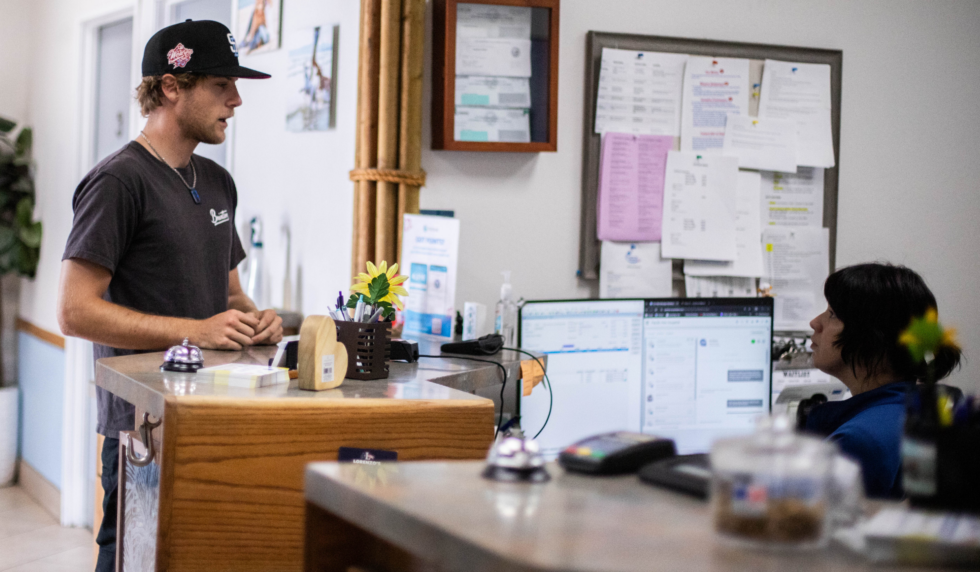 Client and CSR chatting at the front desk while checking out