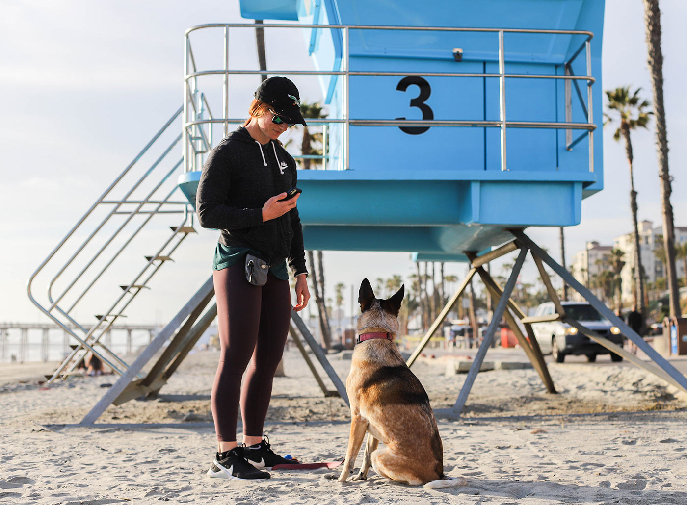 pet parent with dog standing next to lifeguard tower