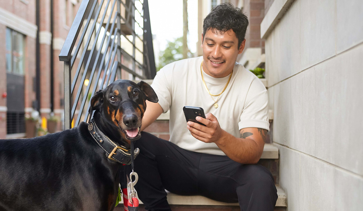 Pet Parent using the PetDesk app while outside with their dog