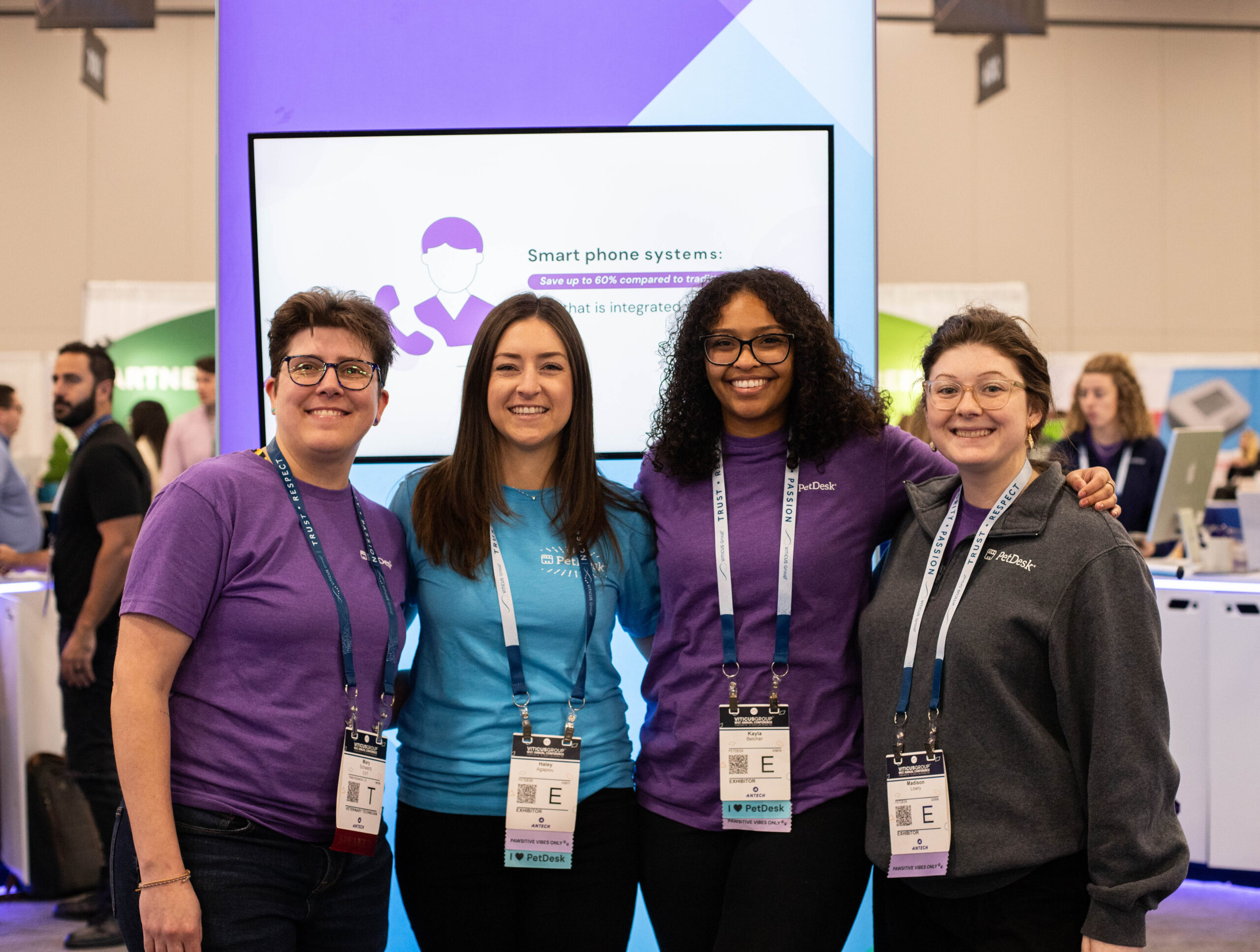 Four PetDeskers happily posing at a tradeshow together