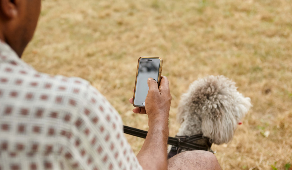 Pet parent using their phone while at the dog park