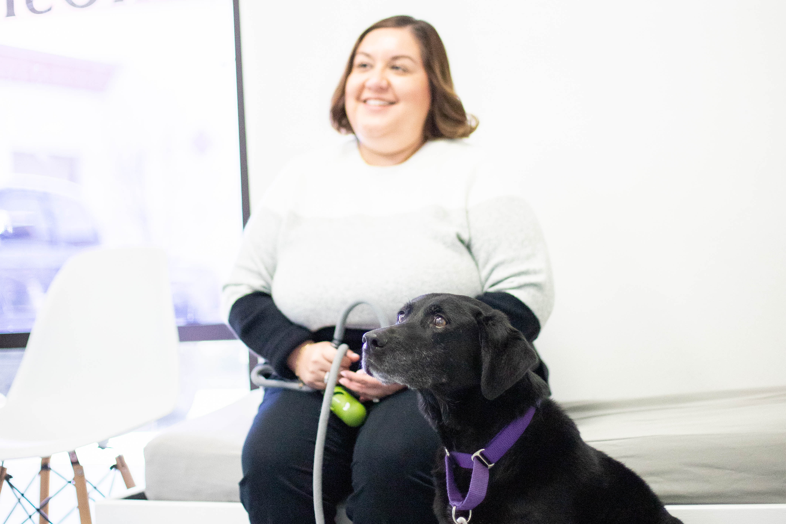 Pet parent happily sitting in the lobby with their dog