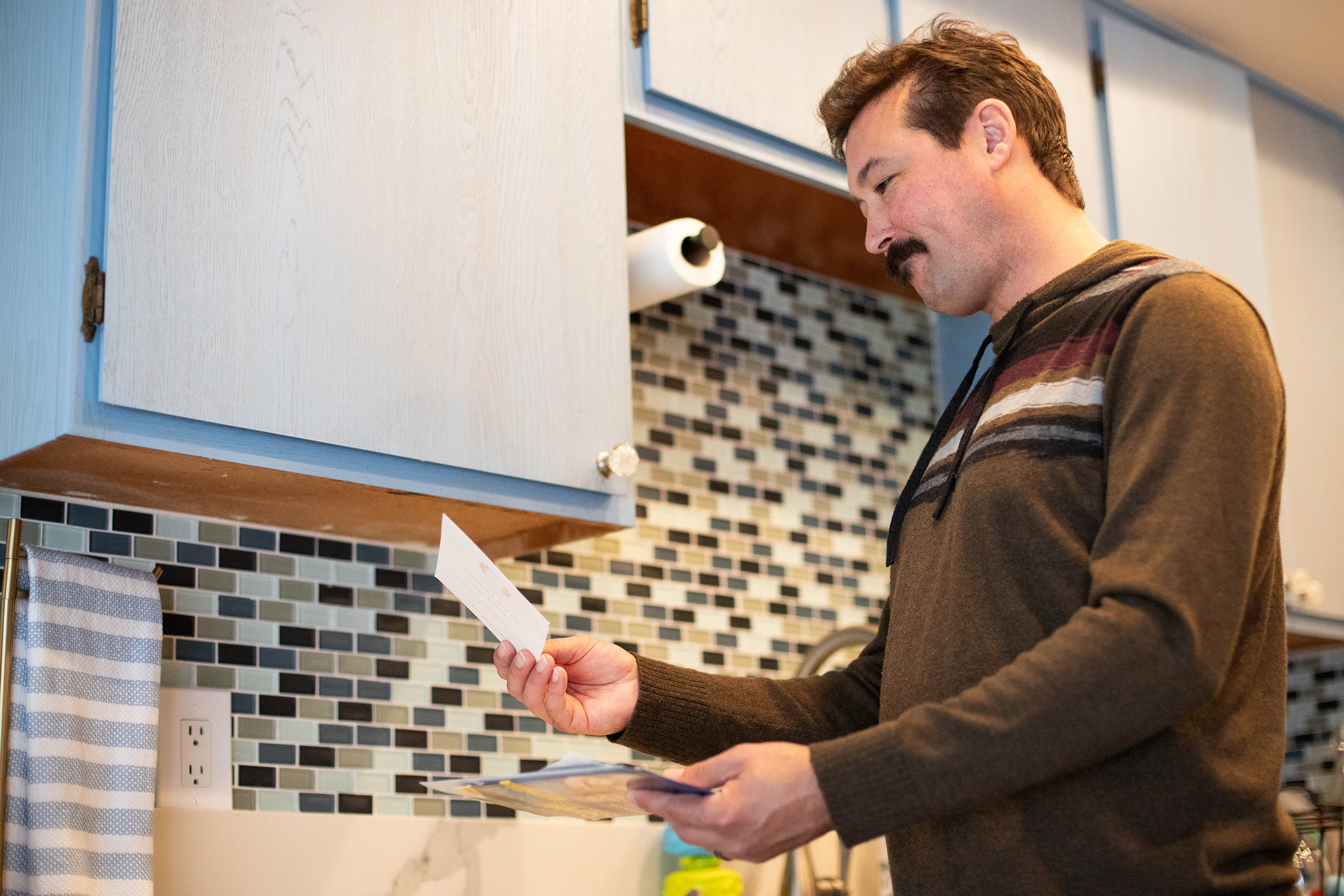 Pet parent looking at a postcard reminder they received in the mail 