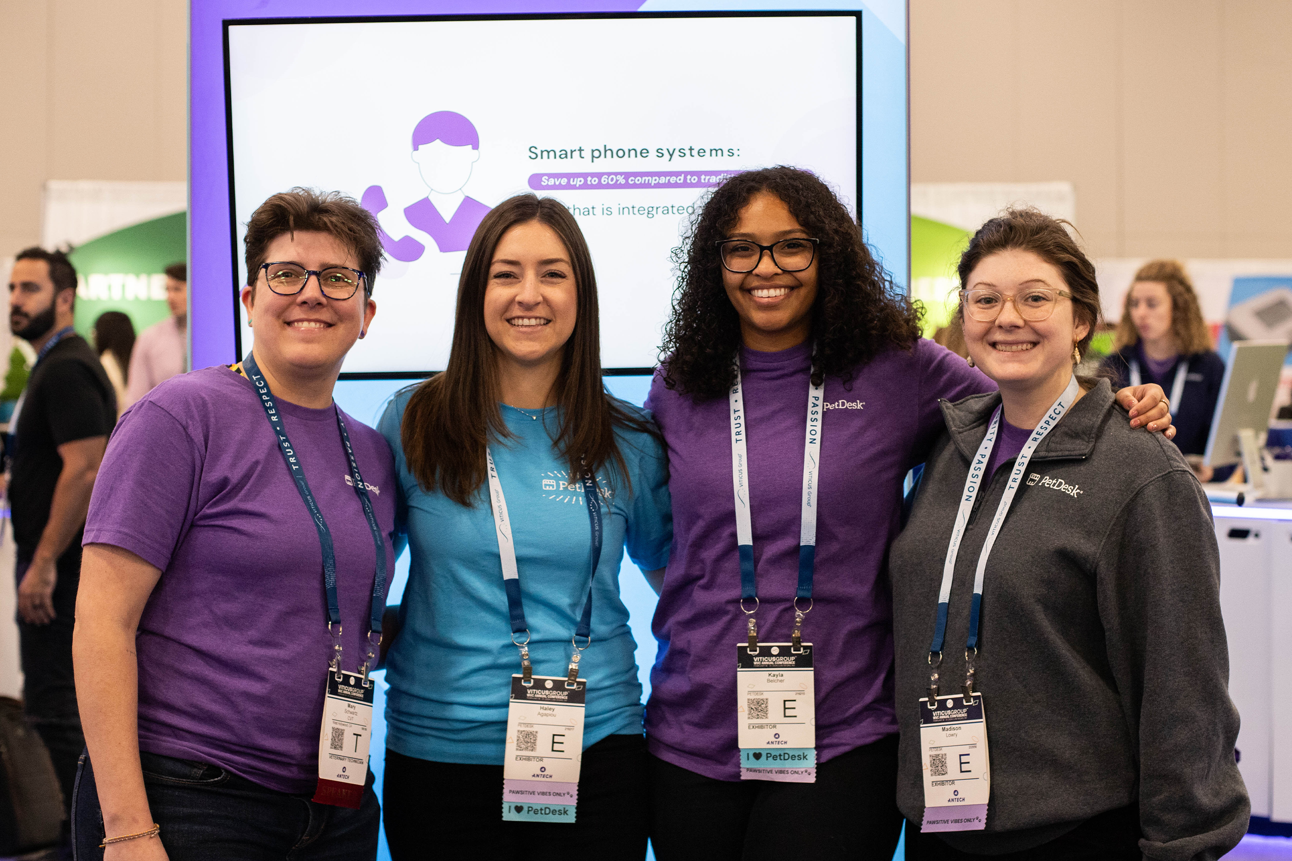 Four PetDesk employees happily posing at a tradeshow